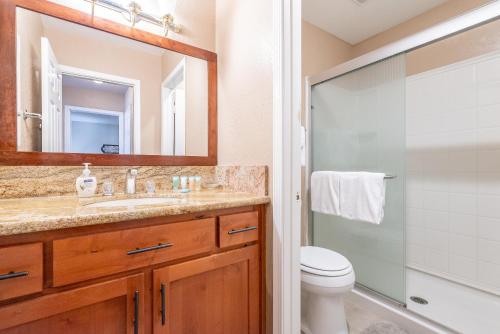Un baño con lavabo, inodoro y espejo. en Bigwood W #90, en Mammoth Lakes