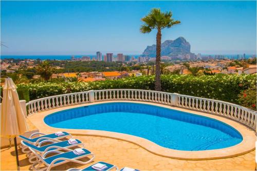 een zwembad met stoelen en een palmboom bij Home SEA&DREAMS NiceView in Calpe