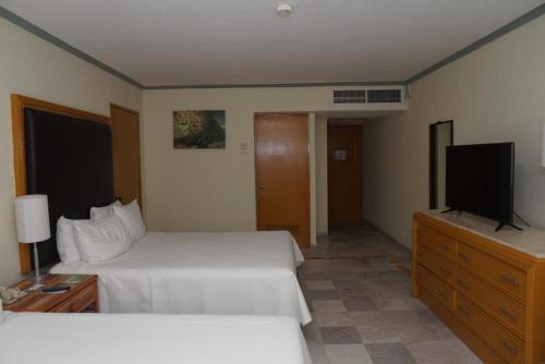 a hotel room with two beds and a flat screen tv at Samba Vallarta All Inclusive in Nuevo Vallarta 