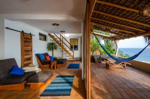 a living room with a hammock and the ocean at Lazuli Cielo - Beachfront Loft in San Agustinillo