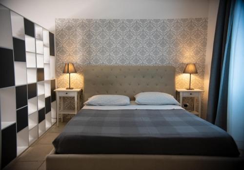 ein Schlafzimmer mit einem Bett mit zwei Lampen an zwei Tischen in der Unterkunft Bed Borgo Antico in Nocera Inferiore