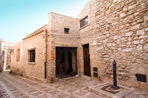 un vieux bâtiment en briques avec une porte dans une rue dans l'établissement Santa Teresa, à Erice