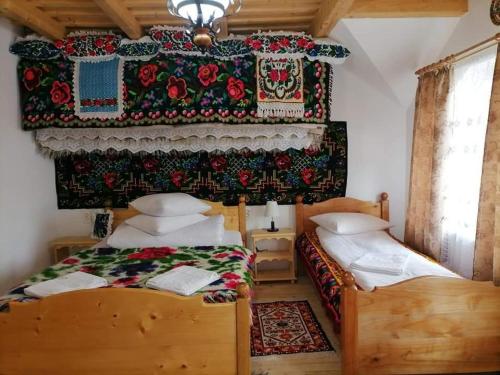 a bedroom with two beds in a room with a wall at Sub Creasta Cocosului in Breb