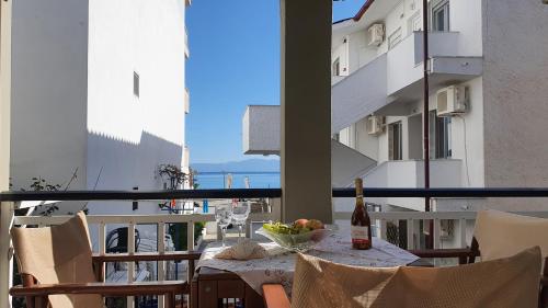 a table with a bottle of wine and a bowl of fruit on a balcony at Villa Pirofani in Sarti