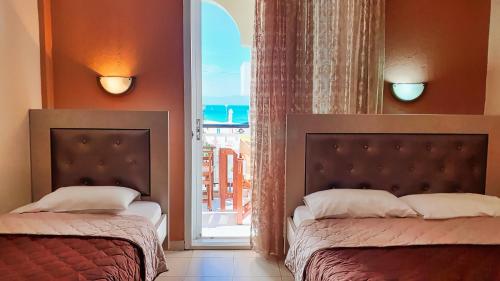 a bedroom with two beds and a window with a view at Villa Pirofani in Sarti