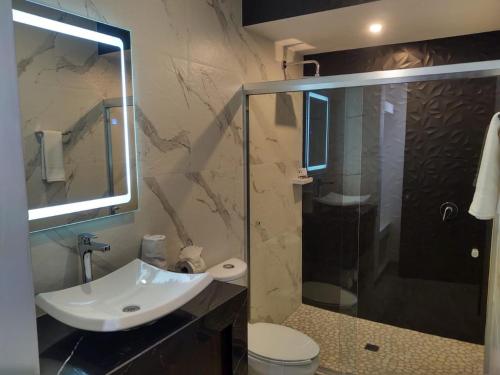 a bathroom with a sink and a glass shower at SAND MAR HOTEL in Puerto Peñasco