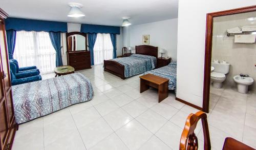una camera d'albergo con due letti e un bagno di Hotel Restaurante Xaneiro a Melide