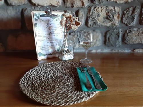 a table with a plate and a glass of wine at Hotel Rural El Rexacu in Bobia de Arriba