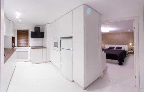 a white kitchen with a bed in a bedroom at The Retreat in Sinaia