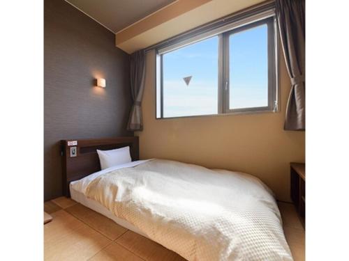 sypialnia z białym łóżkiem i oknem w obiekcie HOTEL FUTABATEI - Vacation STAY 03261v w mieście Kido