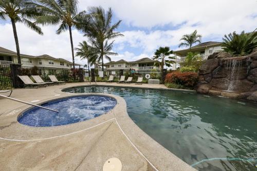 a swimming pool in a resort with palm trees at Plantations at Princeville #1312 in Princeville