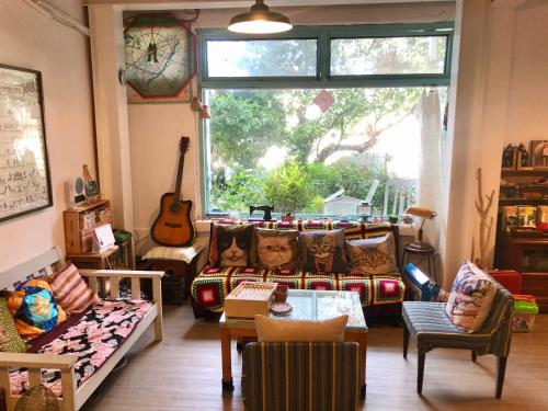 ein Wohnzimmer mit Möbeln und einem großen Fenster in der Unterkunft Meo-Woo Cat Travel b&b in Sanzhi