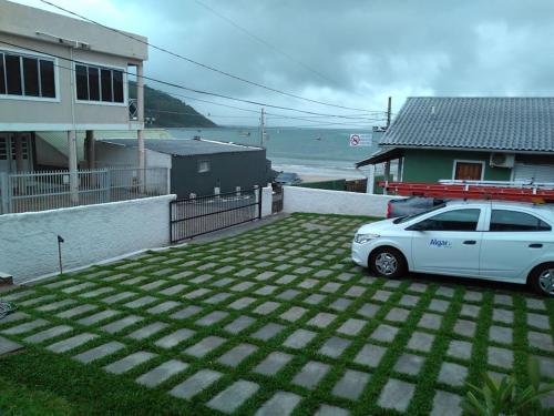 a white car parked in a driveway next to a house at Residencial Mariano 4 - Vista para praia e Mar in Florianópolis