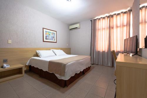 a hotel room with a bed and a television at Hotel Foz do Iguaçu in Foz do Iguaçu