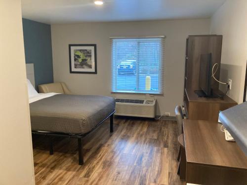 a small bedroom with a bed and a window at Woodspring Suites Cherry Hill in Cherry Hill
