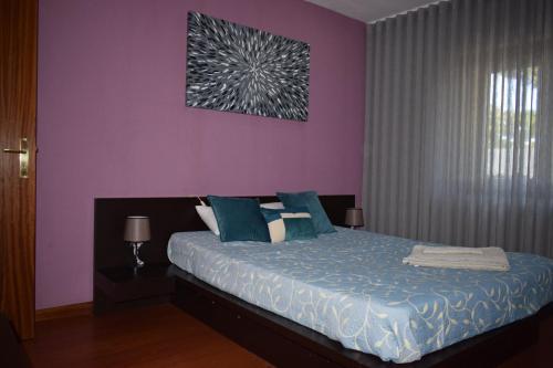 a bedroom with a bed with a purple wall at Parkofir in Fão