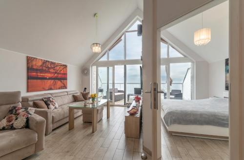 a living room with a bed and a couch at Apartament na Klifowej in Mechelinki