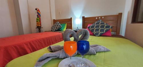 a bedroom with two beds with towels and wine glasses at Lima Airport Hostel with FREE AIRPORT PICK UP in Lima