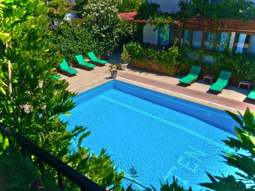 a swimming pool with lounge chairs next to a house at Ten Apart Hotel in Fethiye