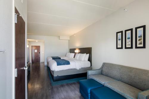 a hotel room with a bed and a couch at Comfort Inn & Suites Gulf Shores East Beach near Gulf State Park in Gulf Shores