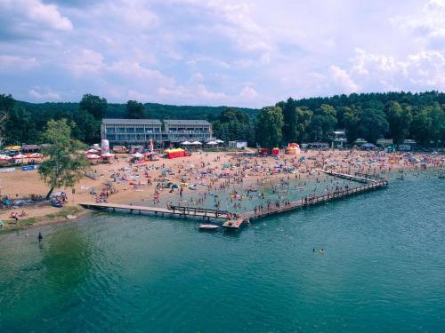 a group of people on a beach with a pier at Pensjonat Długie in Długie