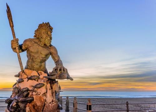 a statue on the beach at sunset at Holiday Inn Va Beach-Oceanside 21st St by IHG in Virginia Beach