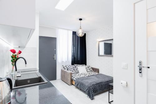ein kleines Schlafzimmer mit einem Bett und einem Waschbecken in der Unterkunft Crystal Apartment Katowice IV in Kattowitz