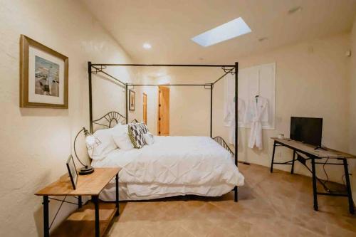 - une chambre avec un lit, un bureau et une télévision dans l'établissement Hacienda del Avion, à Bisbee