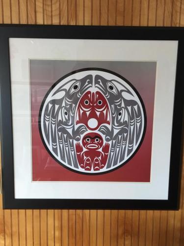 a framed painting of a mask on a wall at Cougar Land Motel in Pullman