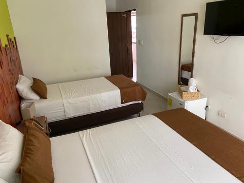 a hotel room with two beds and a mirror at Rivière Boutique Hotel in Medellín
