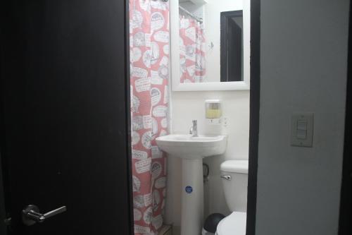 y baño con lavabo, aseo y espejo. en Eden`s Garden Hostel, en Panamá