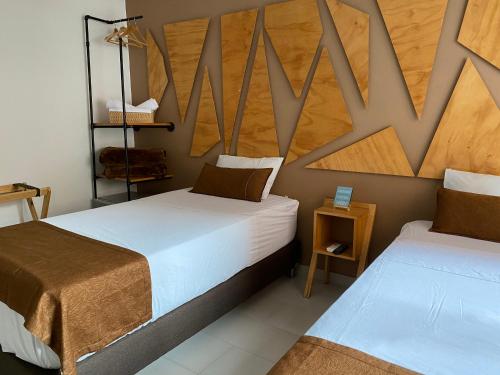 a bedroom with two beds and a wooden wall at Rivière Boutique Hotel in Medellín