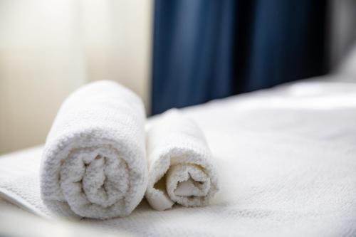 einen Stapel Handtücher auf dem Bett in der Unterkunft Gran Gala in Baia Mare