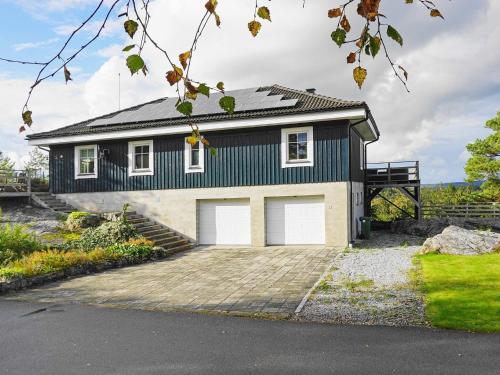 una casa en blanco y negro con garaje en 8 person holiday home in Hen n en Henån