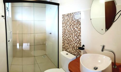 a bathroom with a shower and a toilet and a sink at Pousada Doce Mar in Guarda do Embaú