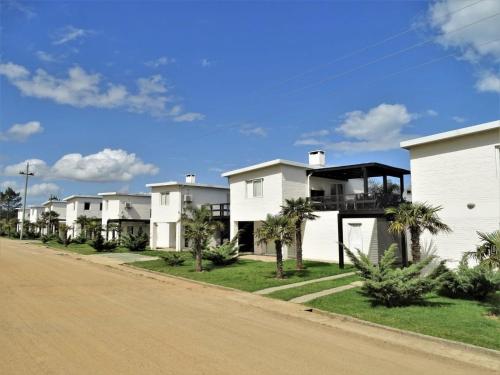 eine Reihe weißer Häuser an der Seite einer Straße in der Unterkunft Skyblue Apart Hotel Punta Colorada in Piriápolis