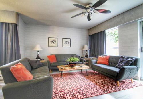 a living room with two couches and a ceiling fan at Best Western Plus Regency Inn and Conference Centre in Abbotsford