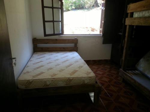 a small bed in a room with a window at Sitio na Serra da Mantiqueira Águas do Canjarana in São Francisco Xavier