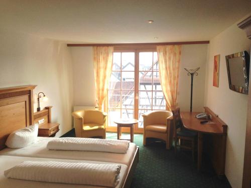 a hotel room with a bed and a desk and a desk at Hotel Ochsen in Friesenheim