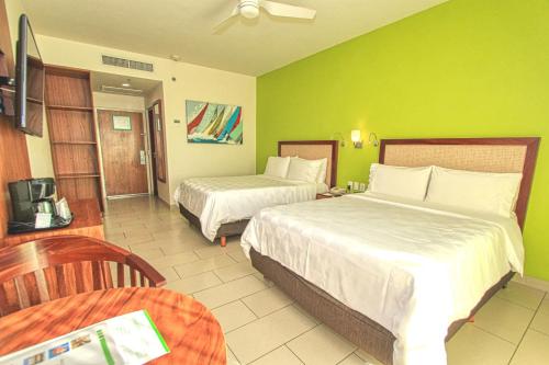Ένα ή περισσότερα κρεβάτια σε δωμάτιο στο Holiday Inn Huatulco by IHG