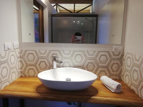 a white sink on a wooden counter in a bathroom at Ibiza Tropical Beach Villas in Uvita
