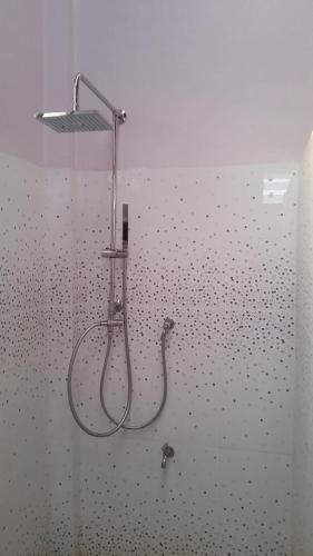 y baño con ducha y pared. en Ban Chang Klang na en Ban Nong Ap Chang