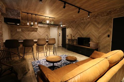a living room with a couch and a bar at Maison Sapporo in Sapporo
