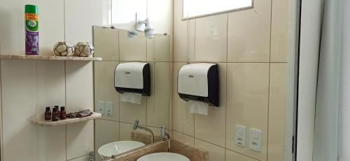 uma casa de banho com 2 lavatórios, um WC e um espelho. em Hotel Pousada Família de Nazaré em Cachoeira Paulista