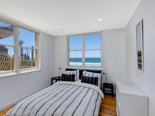 sypialnia z łóżkiem i 2 oknami w obiekcie Golden Sands 1 - Absolute Beachfront w mieście Blue Bay 