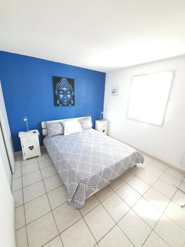 ein Schlafzimmer mit einem Bett und einer blauen Wand in der Unterkunft appartement 4/6 pers in Fréjus