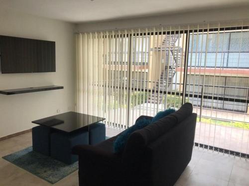 a living room with a couch and a table and a large window at Reserva de la colina Apartasol 215 A in La Tebaida