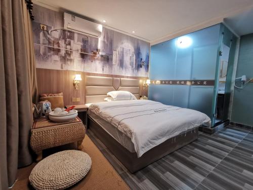 a bedroom with a large bed and a blue wall at Jieyang Yunduo Hotel (Chaoshan Airport) in Jieyang