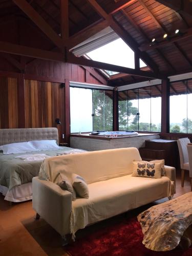 a living room with a couch and a bed at Hospedagem Spa da Alma in Monte Verde