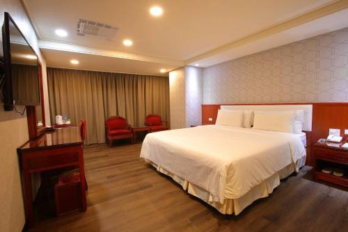 a hotel room with a bed and a television at Chuan Fu Hotel in Fengyuan